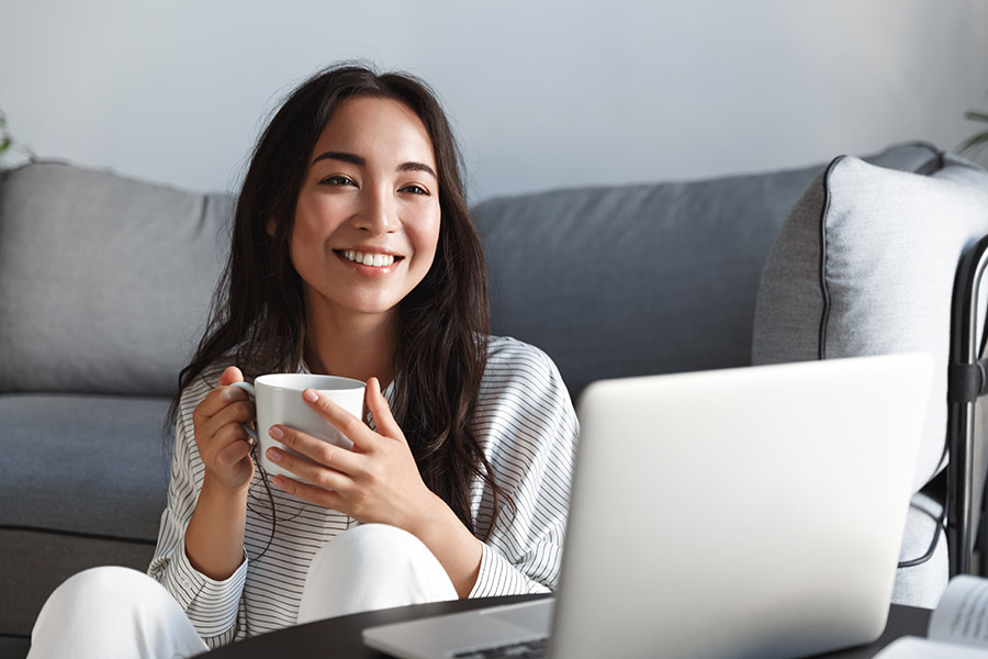 A young lady smiling in front of the laptop